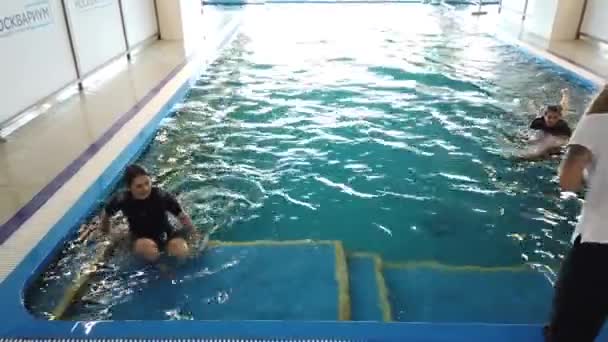 7月26 2020 モスクワ ロシア 女の子はイルカの訓練を受けたイルカと一緒に泳ぐ — ストック動画