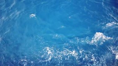 Mavi deniz yüzeyinde yüzen gemiden gelen su izleri. Köpüklü, köpüklü, köpüklü, köpüklü, baloncuklu deniz suyu..