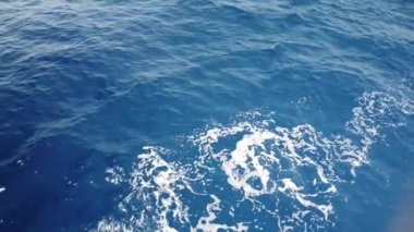 Mavi deniz yüzeyinde yüzen gemiden gelen su izleri. Köpüklü, köpüklü, köpüklü, köpüklü, baloncuklu deniz suyu..