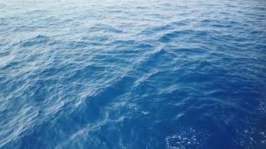 Mavi deniz yüzeyinde yüzen gemiden gelen su izleri. Köpüklü, köpüklü, köpüklü, köpüklü, baloncuklu deniz suyu..