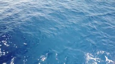 Mavi deniz yüzeyinde yüzen gemiden gelen su izleri. Köpüklü, köpüklü, köpüklü, köpüklü, baloncuklu deniz suyu..