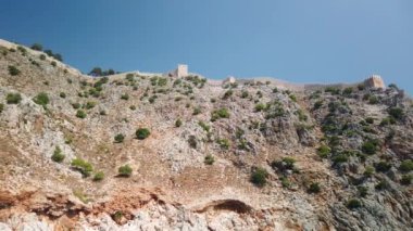 Denizdeki gemi dağın yakınındaki kayalık kıyı boyunca ilerliyor.
