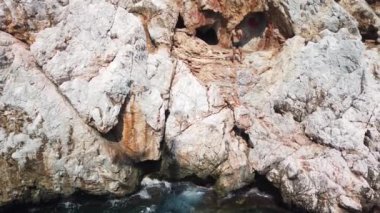 Denizdeki gemi dağın yakınındaki kayalık kıyı boyunca ilerliyor.