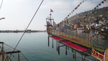 Burnu kanatlı bir aslanla Eski bir korsan gemisinin önünde