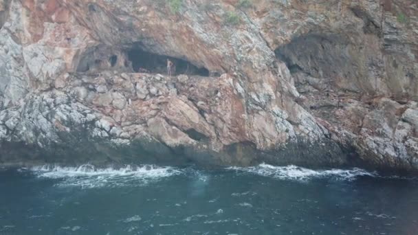 17 SEPTIEMBRE 2020, ANTALIA, TURQUÍA: Un grupo de personas se reunieron en una cueva de montaña por mar y saltaron al agua — Vídeos de Stock