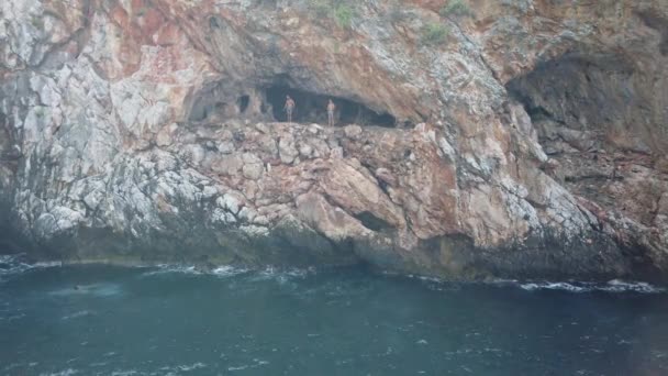 17 SEPTEMBER 2020, ANTALYA, TURKEY: A group of people gathered in a mountain cave by sea and jump into the water — Stock Video