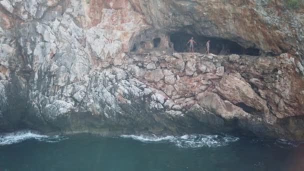 17 SEPTEMBER 2020, ANTALYA, TURKEY: En grupp människor samlades i en bergsgrotta vid havet och hoppade i vattnet — Stockvideo