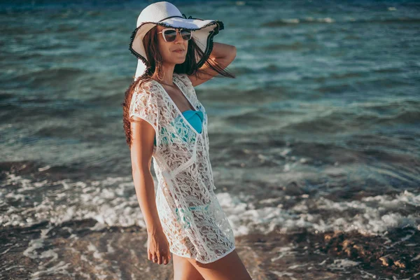 Chica Sonriendo Mientras Está Pie Playa Ventosa Sosteniendo Sombrero —  Fotos de Stock