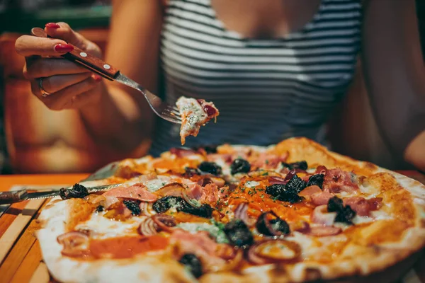 Kadın holding parça pizza restoran çatal üzerinde