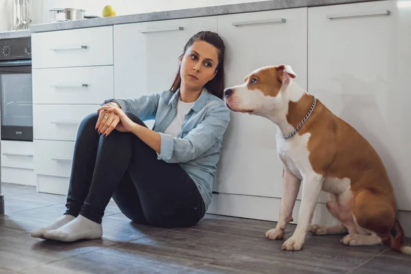 Mutfak katta oturan ve onun köpeği arıyorum üzgün kadın