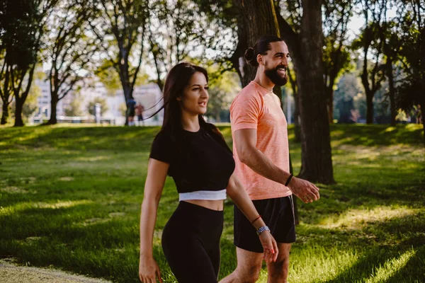 公園で歩くと遠くを見て幸せなカップルに適合します — ストック写真