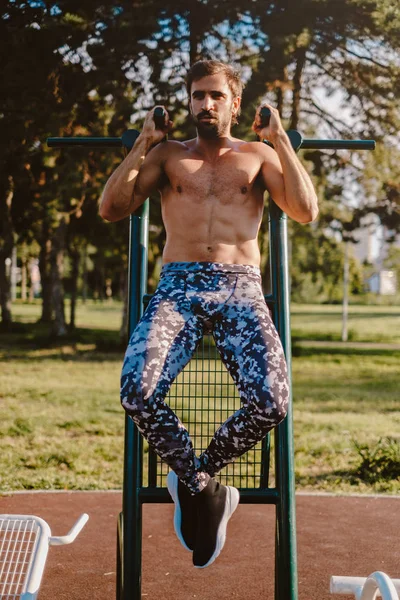 Hombre Guapo Haciendo Pull Ups Fuera —  Fotos de Stock