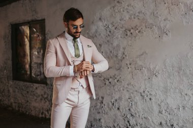 Güneşli bir günde bina koridorda saatine bakarak zarif adam