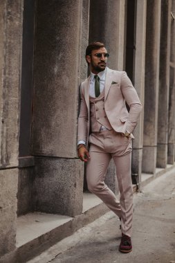 Duvara yaslanmış ve tarafına bakarak rahat iş adamı