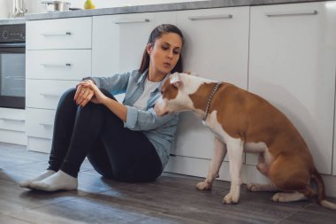 Mutfak katta oturan ve köpeğini öpücüğü vermeye kız