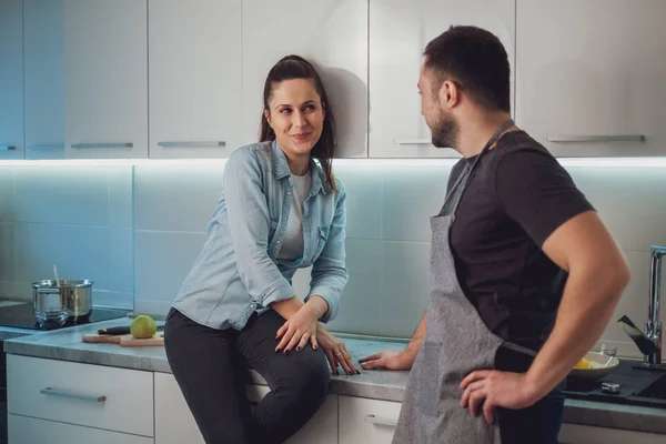 Sorrindo Menina Flertando Com Seu Namorado Enquanto Sentado Bancada Cozinha — Fotografia de Stock