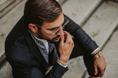 Merdivenlerde oturan ve düşünme ciddi yakışıklı işadamı