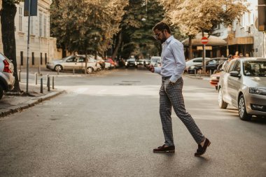 Eli cebinde cep telefonu karşıdan karşıya geçerken seyir ile dikkatsiz yakışıklı adam