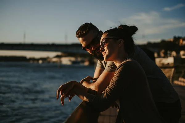 川の夕日を楽しんで愛のカップル 美しい晴れた日 — ストック写真