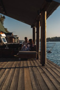 Bir kaç gün batımı nehir kenarında otururken savunarak. Güzel sonbahar günü