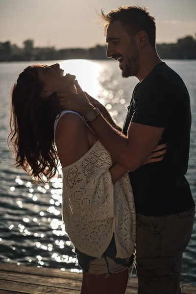 愉快的情侣拥抱和笑声在河边日落 美丽的秋日 — 图库照片