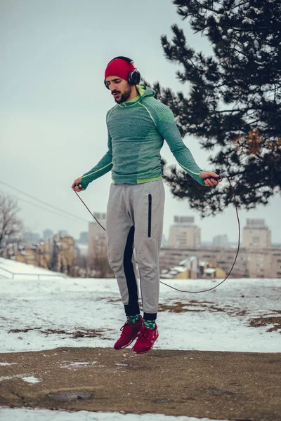 Hombre Musculoso Enfocado Saltando Cuerda Afuera Día Invierno Con Auriculares —  Fotos de Stock