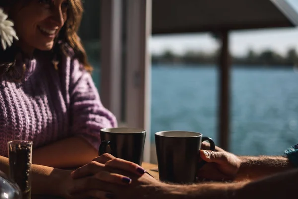 幸福的夫妇拿着一杯咖啡和双手在阳光下 河在背景中 — 图库照片