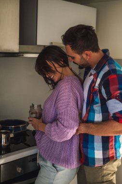 Mutfakta kahve yapıyor güzel gülümseyen eşi tutarken adam