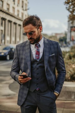 Sokakta duran cep telefonu bakarak işadamı
