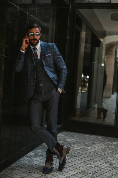Duvara yaslanmış ve telefonda konuşurken işadamı