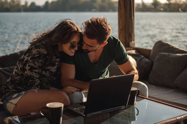 幸福的夫妇微笑着 在河边的笔记本电脑工作在一个阳光明媚的日子 — 图库照片