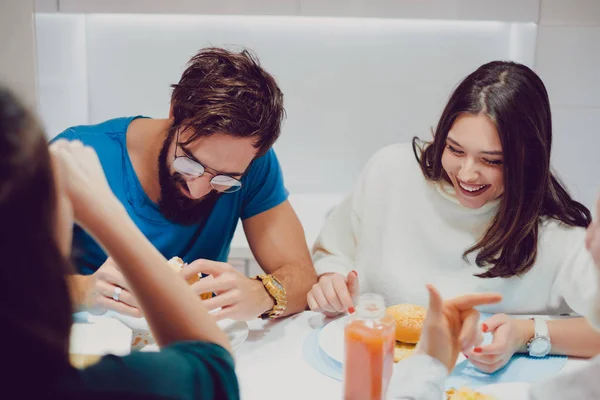 Девушка смеется во время обеда с друзьями — стоковое фото