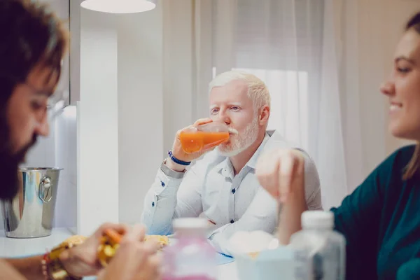 Albino homem bebendo suco no jantar com os amigos — Fotografia de Stock