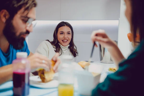 Girl smiling and talking while having lunch with friends — Stock Photo, Image