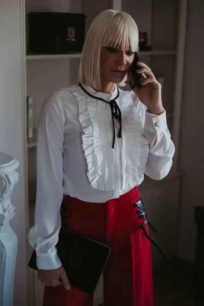 Serious businesswoman talking on the phone in the living room — Stock Photo, Image