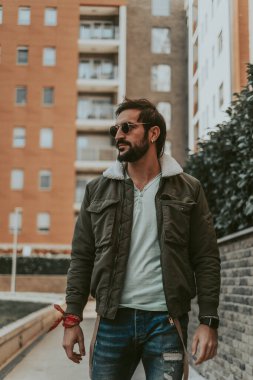 Yakışıklı, şık, sakallı adam Teh şehrinde yalnız yürüyor.
