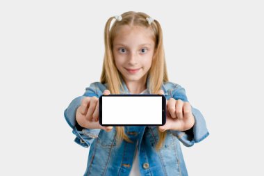 Elinde akıllı telefon tutan bir kız ve mesaj atmak için beyaz bir yeri var. Telefona odaklan. Arkaplan bulanık