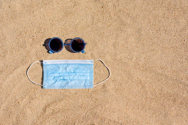 Óculos Sol Uma Máscara Médica Estão Praia Areia Vista — Fotografia de Stock