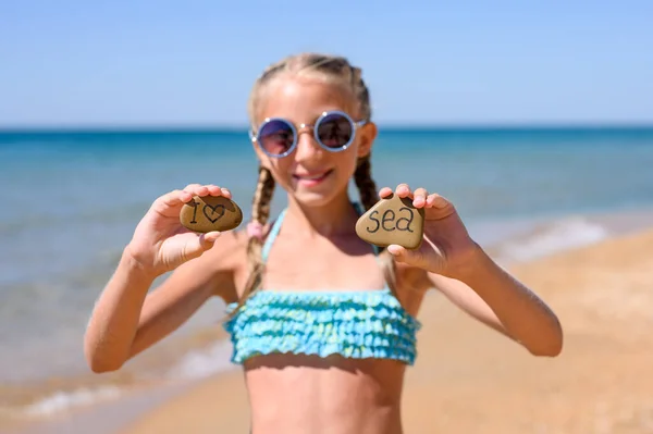 Menina Alegre Óculos Sol Praia Fica Mostra Duas Pedras Com — Fotografia de Stock