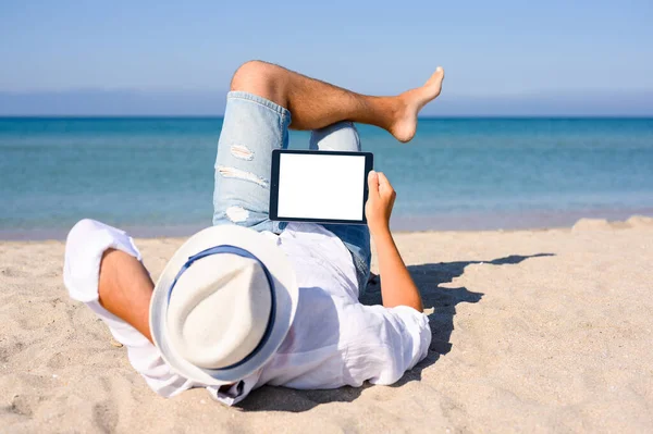 Homem Deita Numa Praia Areia Com Tablet Mar Está Fundo — Fotografia de Stock