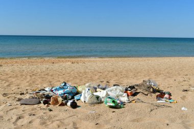 Anapa, Krasnodar Toprakları / Rusya - Ağustos 2020: Kumlu bir sahilde turistlerin çöpleri denizin arka planına karşı.