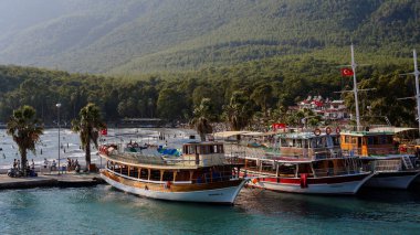 Marmaris, Mugla / Türkiye - Ağustos 2018: Türk tatil beldesi yakınlarındaki turistik yatlar. Dağların arka planında yatlar.