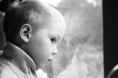 Sevimli küçük çocuk çocuk şehir tren pencereden dışarı bakarak beyaz tişört. Çocuk demiryolu ile seyahat. Genç yolcusu. Nesne.