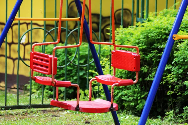 Parktaki ve dışarıdaki çocuklar için kırmızı çifte salıncak.