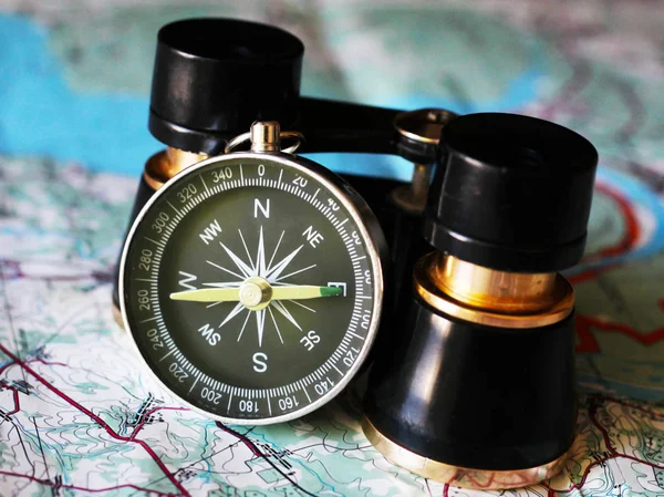 Old compass and binoculars on the map, retro