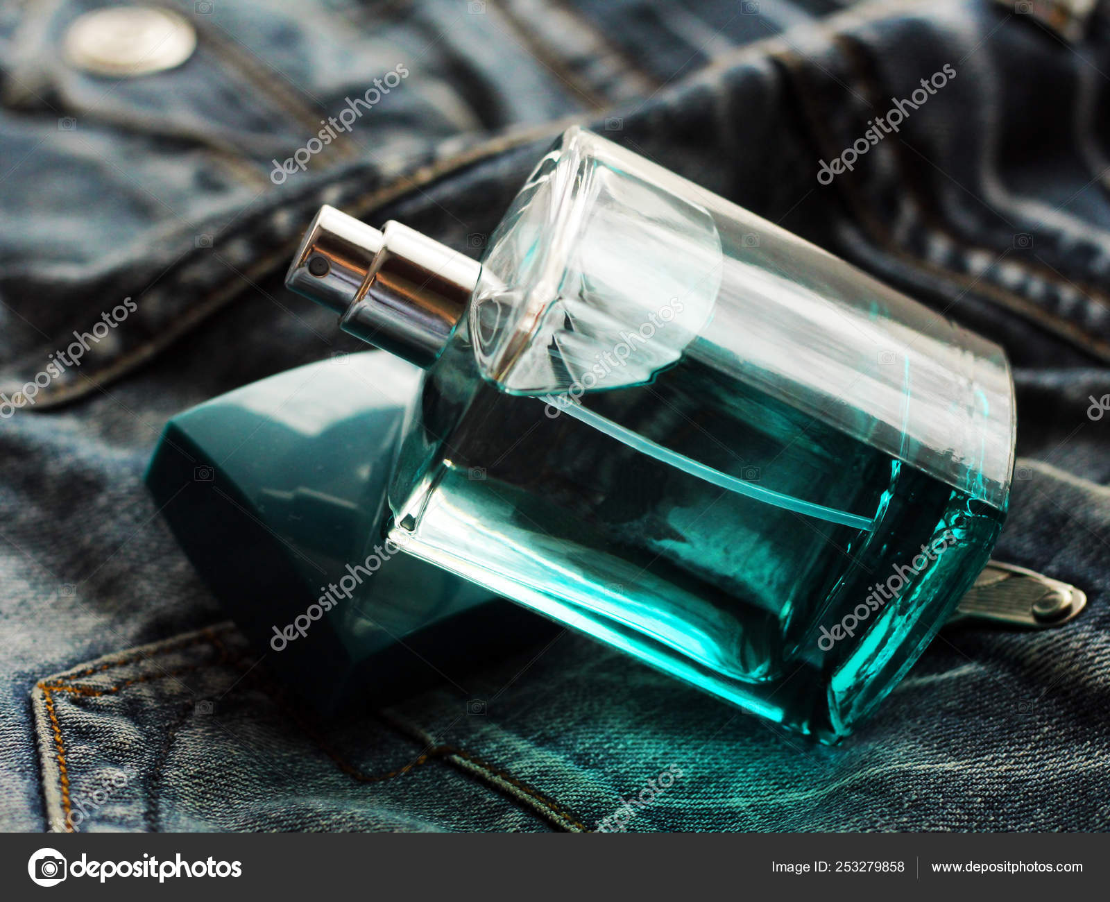 Men's green perfume in beautiful bottle on jeans — Stock Photo