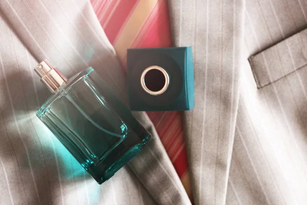 Men's perfume in beautiful bottle on the grey jacket — Stock Photo, Image