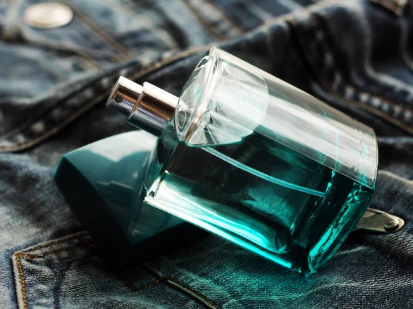 Zielone perfumy męskie w pięknej butelce na dżinsy — Zdjęcie stockowe