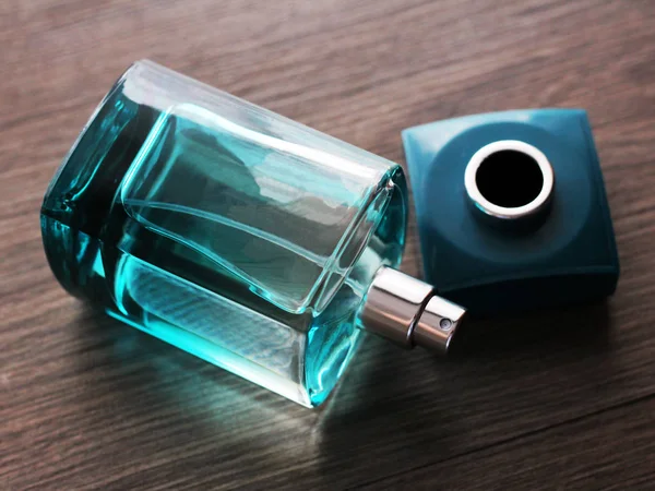 Perfume verde de los hombres en hermosa botella sobre fondo de madera —  Fotos de Stock