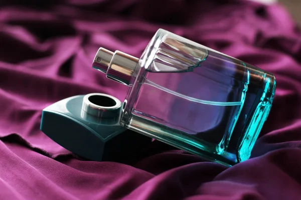 Fles parfum op een Lila jurk — Stockfoto